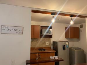 uma cozinha com um frigorífico, uma mesa e luzes em Apartamento en Manizales em Manizales