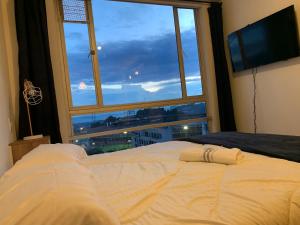 um quarto com uma cama e uma grande janela em Apartamento en Manizales em Manizales