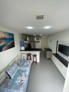 a living room with a couch and a kitchen at Apartamento na Praia de Guaibim in Guaibim