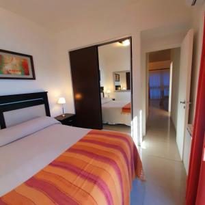 Habitación de hotel con cama y espejo en Torre Myng en Villa Carlos Paz