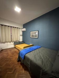 ein Schlafzimmer mit 2 Betten und einer blauen Wand in der Unterkunft Residencial Praia do Flamengo - Zona Sul Rio de Janeiro in Rio de Janeiro