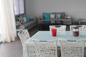 a table and chairs in a living room with a couch at Eden Island Villa - Bouznika in Bouznika