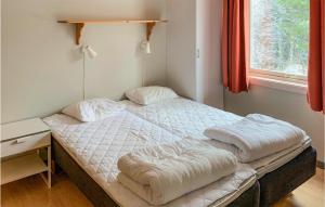 a bed with two pillows on it in a room at Awesome Apartment In Transtrand With Sauna, Wifi And 3 Bedrooms in Transtrand