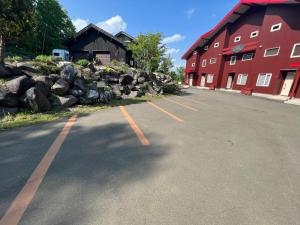 an empty parking lot in front of a red building at Chalet Fuyuri in Furano