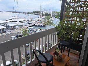 un balcone con 2 sedie e un porto turistico con barche di Superbe appartement au coeur de la Marina a Pointe-à-Pitre