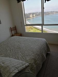 a bedroom with a bed and a large window at Departamento Costa Quilén, Puchuncaví. (10 min de Maitencillo) in Valparaíso