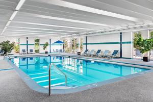 a large swimming pool with blue water in a building at Four Points by Sheraton London in London