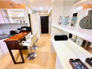 um quarto com uma secretária e uma cozinha com prateleiras brancas em D Peaceful and Comfortable Room em Iloilo
