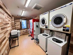 a laundry room with washing machines and a washer and dryer at Hotel New Saitama in Saitama