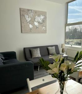 un soggiorno con divano e tavolo con fiori di 2 Bedroom Flat Ground Floor in Town Center a Wellingborough