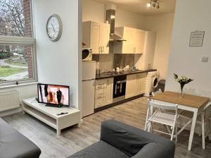 a living room with a kitchen and a table with a tv at 2 Bedroom Flat Ground Floor in Town Center in Wellingborough