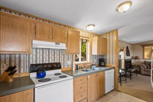 a kitchen with wooden cabinets and a white stove top oven at Alpine #3 in West Yellowstone