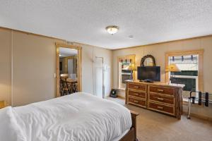 Dormitorio con cama y tocador con TV en Alpine #3 en West Yellowstone