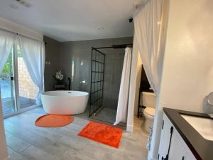 a large bathroom with a tub and a toilet at Dreamy Palm Springs Villa w Pool, Spa, Great Views in Palm Springs