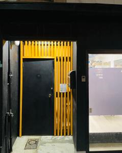 uma porta preta com guarnição amarela num edifício em Ebisu-Sakura 恵美須～桜 em Osaka