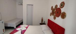 a white bedroom with a bed with a red headboard at Capitolio Canoa Quebrada in Canoa Quebrada +25 photos