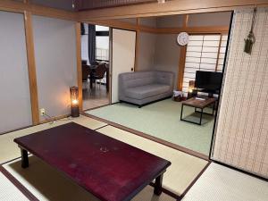 a living room with a couch and a table at Hiroshima Danbara LiBPLUS in Hiroshima