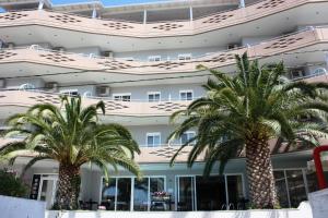 dwie palmy przed budynkiem w obiekcie Hotel Cariatis w miejscowości Nea Kallikratia