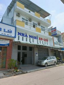 a building with a car parked in front of it at Eo Gió Motel in Hưng Lương