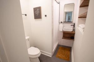 Un baño blanco con inodoro y lavabo. en J Birds' Cottage Midtown Memphis, en Memphis 9 fotos más