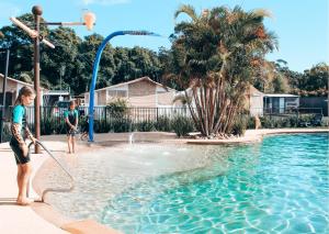 two children playing in the water in a swimming pool at Jervis Bay Holiday Park in Huskisson