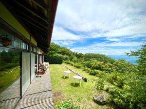 un porche de una casa con 2 sillas y un banco en Kiyo's Gokokuen "Tatsumado" - Vacation STAY 77728v, en Kasama