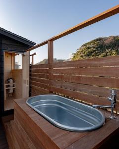 a bath tub on a deck with a large window at 3rd House Inamuragasaki in Kamakura