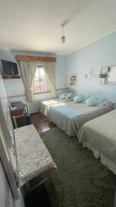 Habitación de hotel con 2 camas y sofá en Pousada Ararinha Azul, en Campos do Jordão
