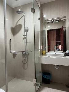 y baño con ducha, lavabo y espejo. en Khách Sạn Sông Lô en Hải Dương