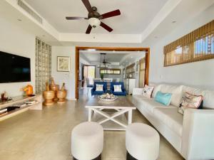 een woonkamer met een witte bank en een plafondventilator bij Bright Gorgeous Fully Equipped Villa W- Pool in Juan Dolio