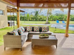 een woonkamer met een bank en een tafel bij Bright Gorgeous Fully Equipped Villa W- Pool in Juan Dolio