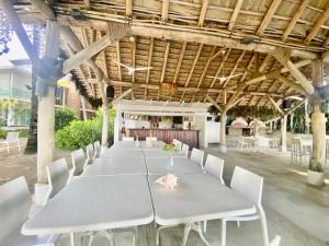 einen langen Tisch mit weißen Stühlen in einem Pavillon in der Unterkunft Stunning Beachfront Condo With Private Beach, Las Terrenas-el Limn in El Limón