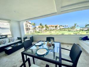 a table and chairs in a living room with a view of the ocean at New! Beachfront Lux Condo With Private Jacuzzi in Punta Cana