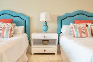 a bedroom with two beds and a blue lamp on a night stand at New! Beachfront Lux Condo With Private Jacuzzi in Punta Cana
