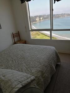 - une chambre avec un lit et une grande fenêtre dans l'établissement Departamento Costa Quilen (10 min Maitencillo), à Valparaíso