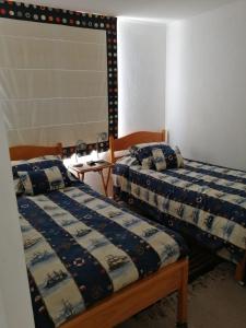 dos camas sentadas una al lado de la otra en una habitación en Departamento Costa Quilen (10 min Maitencillo), en Valparaíso