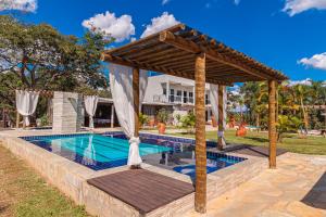 a pool with a gazebo next to a house at Pousada Nobre Vista in Pirenópolis