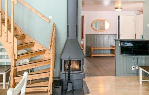 a fireplace in a living room with a staircase at Awesome Apartment In Transtrand With Sauna, Wifi And 3 Bedrooms in Transtrand