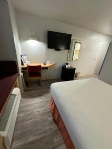 a hotel room with a bed and a desk at Microtel Inn & Suites by Wyndham Gallup - PET FRIENDLY in Gallup