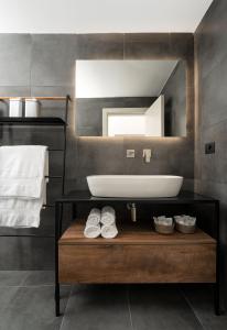 ein Badezimmer mit einem Waschbecken und einem großen Spiegel in der Unterkunft Casa800 in Capri