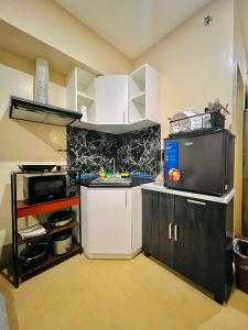 uma pequena cozinha com um lavatório e um micro-ondas em * * * E Best Value Room for up to 3 em Iloilo