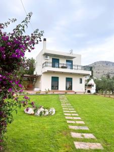 a house with a green yard with flowers at Villa Calliope Lardos in Lartos