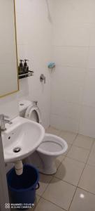 a bathroom with a white toilet and a sink at D&Q METROCITY GUESTHOUSE in Kuching