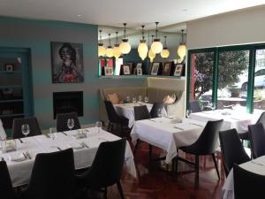 un ristorante con tavoli e sedie bianchi e un camino di Ten Bompas Hotel a Johannesburg