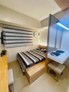 a bedroom with a bed and a desk and a window at * * * F Best Value in Iloilo in Iloilo City