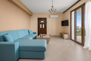sala de estar con sofá azul y TV en Lakis Residence, en Vlachata