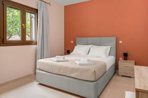 1 dormitorio con 1 cama con paredes de color naranja y ventana en Lakis Residence, en Vlachata