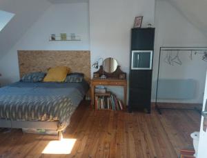 1 dormitorio con 1 cama y suelo de madera en Chez Agathe et Mathieu en Le Mans