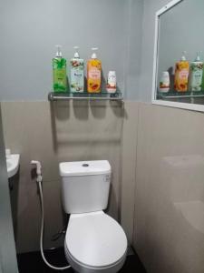 a bathroom with a toilet and a sink and a mirror at Z&j Transient House in Butuan