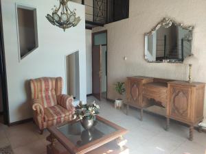 a living room with a chair and a table and a mirror at Habitación con baño privado y estacionamiento in San Martín